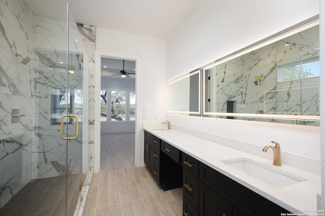 bathroom featuring a sink, a marble finish shower, wood finish floors, and double vanity