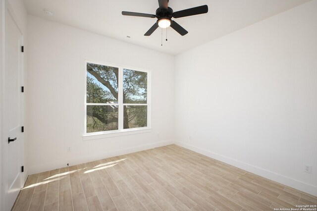 unfurnished room featuring a ceiling fan, baseboards, and wood finished floors