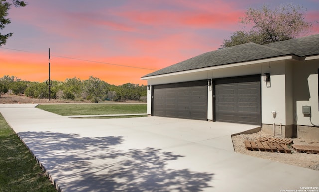 view of garage at dusk