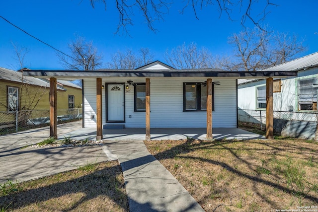 view of front of house with covered porch, a front lawn, and fence