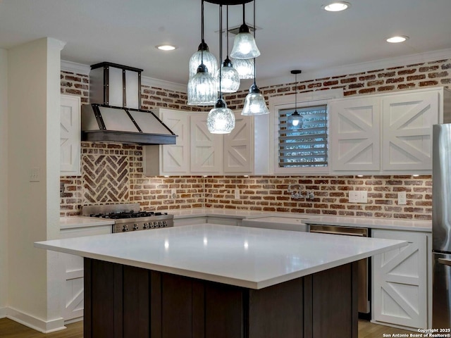 kitchen featuring stove, white cabinets, light countertops, and brick wall