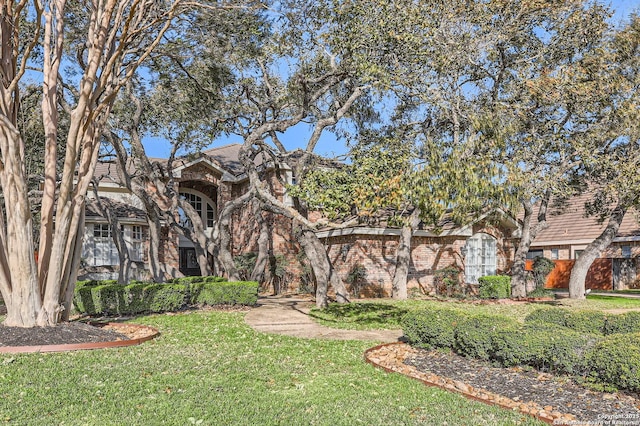 view of front of house featuring a front yard and brick siding