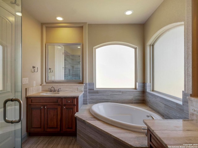 full bath featuring a bath, recessed lighting, a shower stall, and vanity