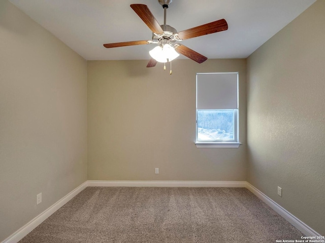 carpeted empty room featuring baseboards and a ceiling fan