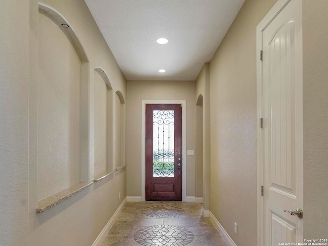 entryway with stone finish floor, recessed lighting, and baseboards