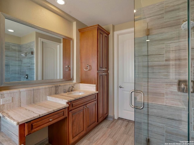 bathroom featuring recessed lighting, vanity, and a shower stall