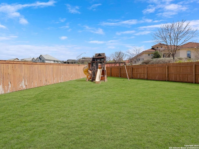 view of yard featuring a playground and a fenced backyard