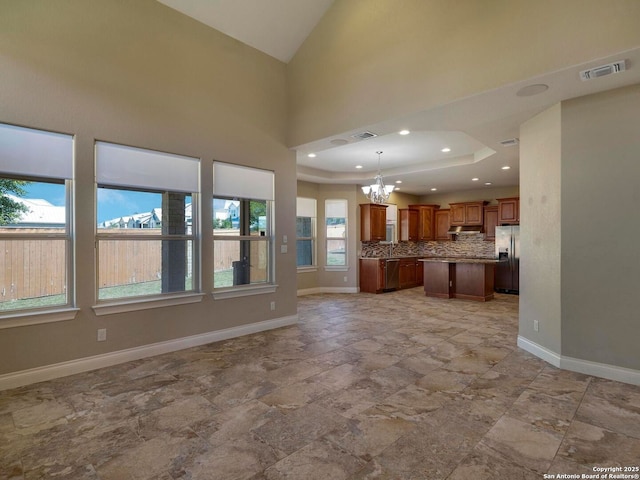 unfurnished living room with a notable chandelier, visible vents, recessed lighting, and baseboards