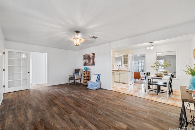 unfurnished room featuring visible vents, a sink, baseboards, and wood finished floors