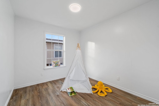 recreation room featuring wood finished floors and baseboards