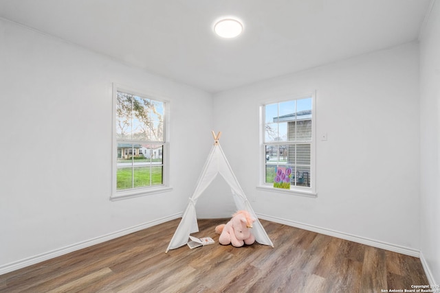 recreation room featuring baseboards and wood finished floors