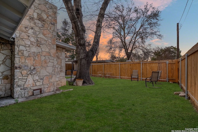 yard at dusk with a fenced backyard