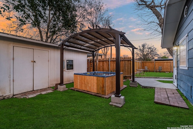 yard at dusk with a patio, a hot tub, a pergola, and fence