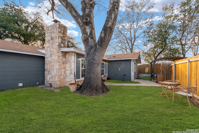 rear view of property featuring a yard and fence