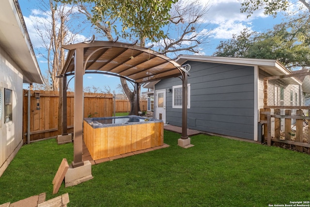 view of yard featuring a carport, a fenced backyard, and a hot tub