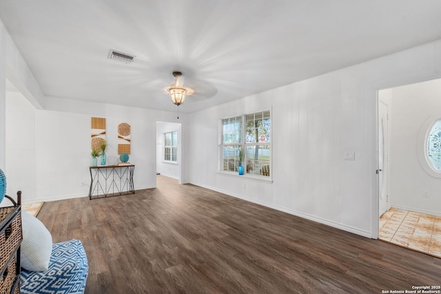 living area with wood finished floors, visible vents, and baseboards