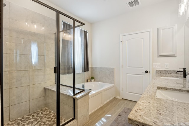 bathroom with a sink, visible vents, a bath, and a shower stall