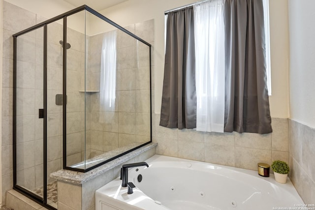 bathroom with a shower stall and a whirlpool tub