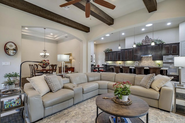 living room featuring beam ceiling, arched walkways, visible vents, and a towering ceiling