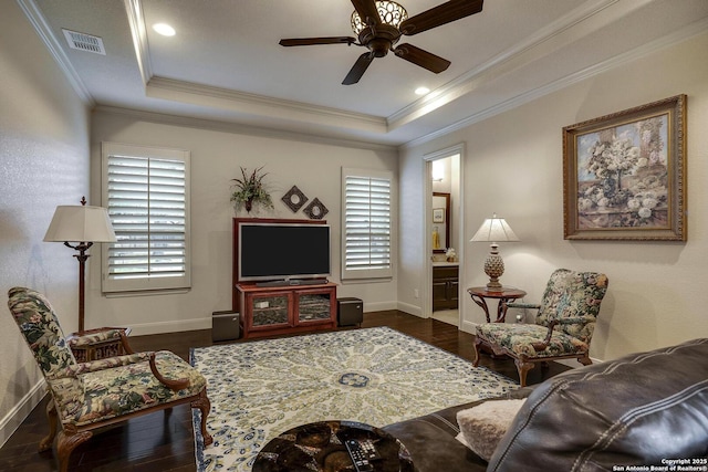 living room featuring a raised ceiling, a healthy amount of sunlight, visible vents, and dark wood-style flooring