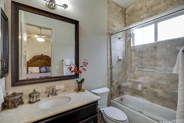 ensuite bathroom with bath / shower combo with glass door, toilet, vanity, a textured wall, and ensuite bath