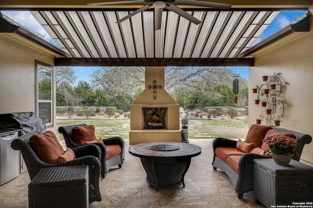 view of patio featuring ceiling fan and an outdoor living space with a fireplace