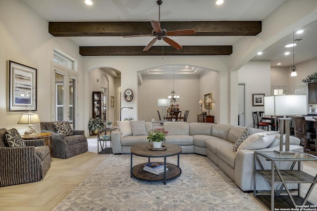 living room featuring arched walkways, beam ceiling, recessed lighting, and ceiling fan with notable chandelier