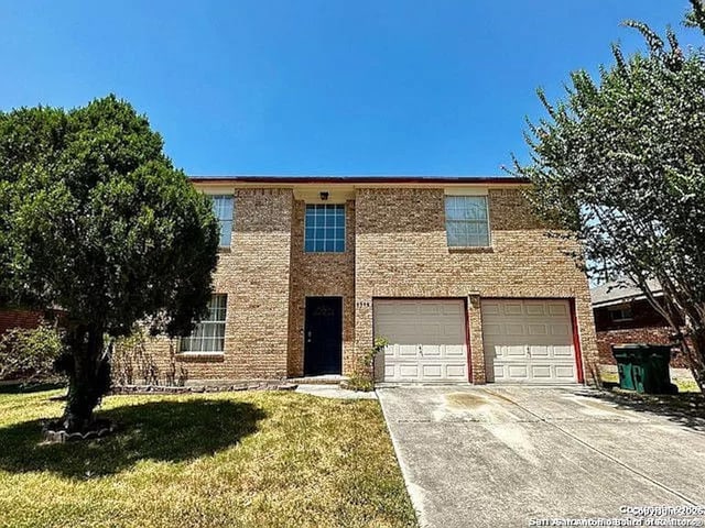 view of front facade featuring a garage, brick siding, concrete driveway, and a front yard