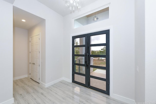 foyer featuring wood finished floors, french doors, and baseboards