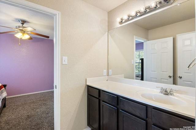 bathroom featuring baseboards, vanity, ceiling fan, and a textured wall