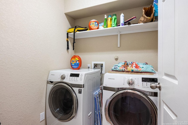 laundry room featuring washer and clothes dryer, laundry area, and a textured wall