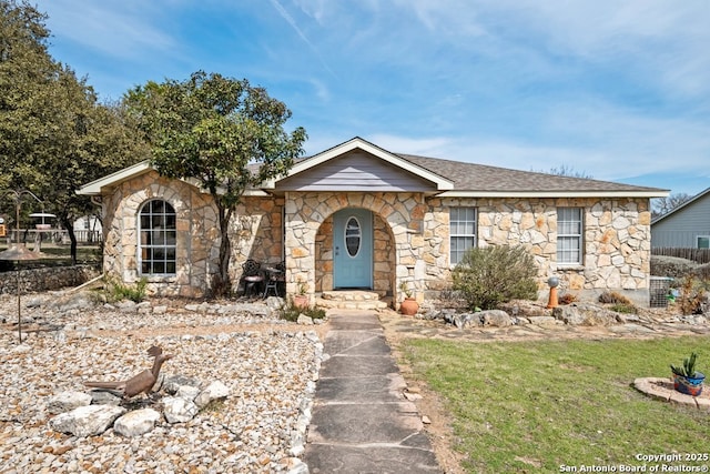 view of front facade featuring a shingled roof and a front lawn