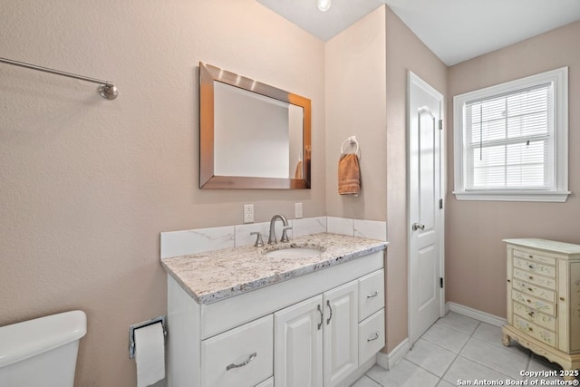 bathroom featuring tile patterned flooring, toilet, vanity, and baseboards