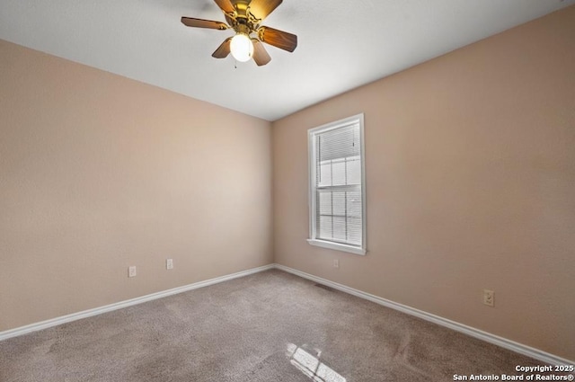 carpeted empty room with a ceiling fan and baseboards