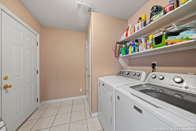 laundry room featuring visible vents, baseboards, light tile patterned floors, laundry area, and separate washer and dryer