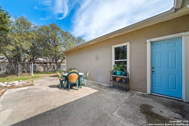 view of patio with outdoor dining area and fence