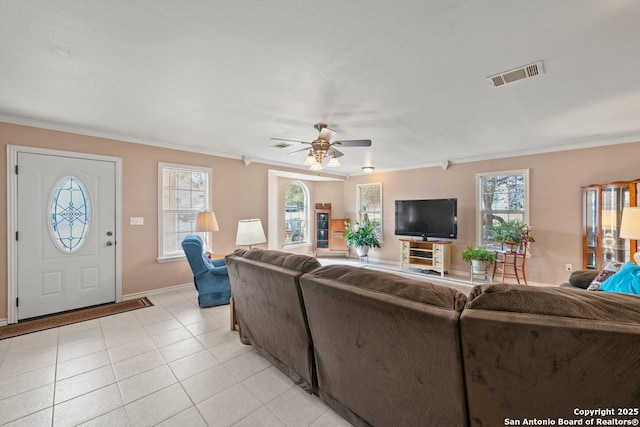 living room featuring light tile patterned flooring, visible vents, crown molding, and a ceiling fan