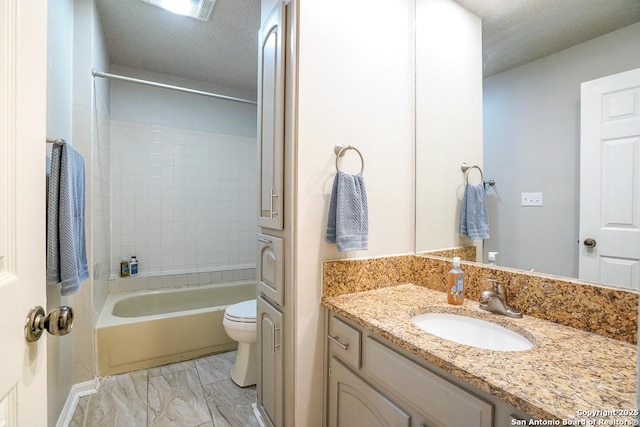 bathroom with vanity, toilet, marble finish floor, and a textured ceiling