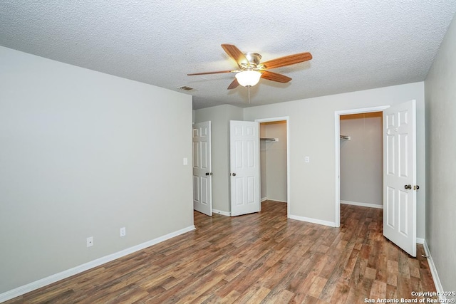 unfurnished bedroom featuring baseboards, a textured ceiling, and wood finished floors