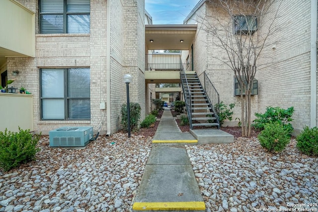 property entrance with central air condition unit and brick siding