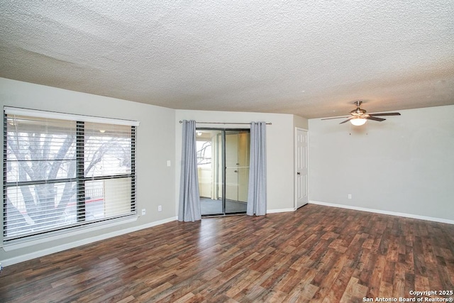 empty room featuring a textured ceiling, baseboards, and wood finished floors