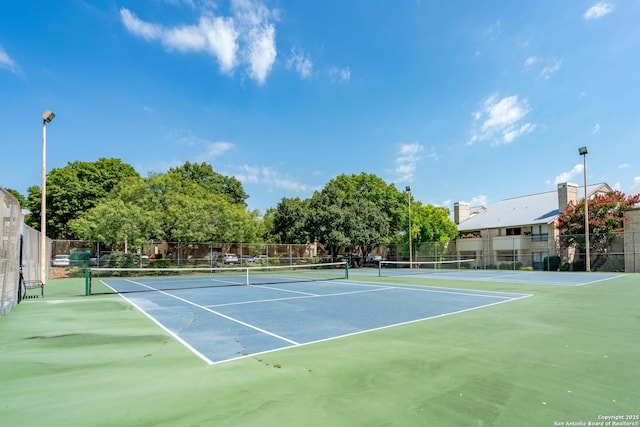 view of tennis court featuring fence