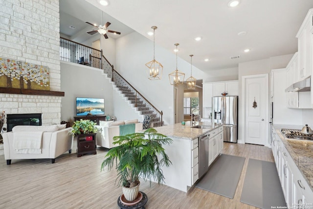 12519 Upton Park, San Antonio, TX 78253 - kitchen with visible vents, under cabinet range hood, a fireplace, stainless steel appliances, and a sink