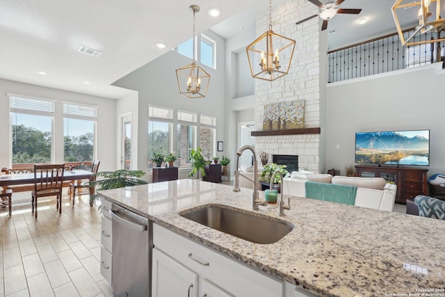 12519 Upton Park, San Antonio, TX 78253 - kitchen featuring visible vents, a healthy amount of sunlight, a brick fireplace, dishwasher, and a sink