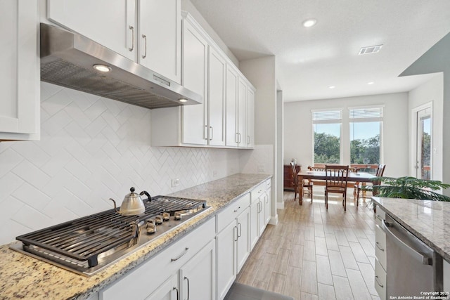 12519 Upton Park, San Antonio, TX 78253 - kitchen with visible vents, under cabinet range hood, tasteful backsplash, appliances with stainless steel finishes, and white cabinets