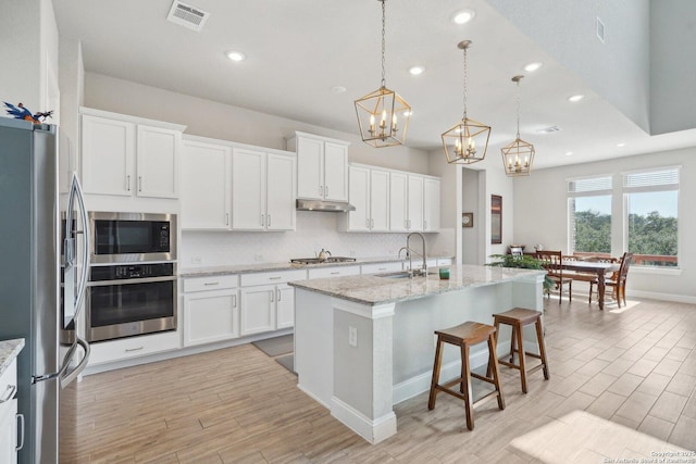 12519 Upton Park, San Antonio, TX 78253 - kitchen with visible vents, under cabinet range hood, a sink, stainless steel appliances, and decorative backsplash