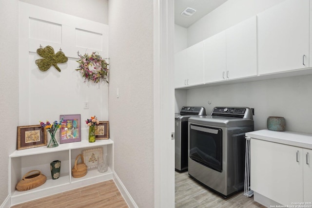 12519 Upton Park, San Antonio, TX 78253 - laundry room featuring washing machine and clothes dryer, visible vents, baseboards, light wood-style flooring, and cabinet space
