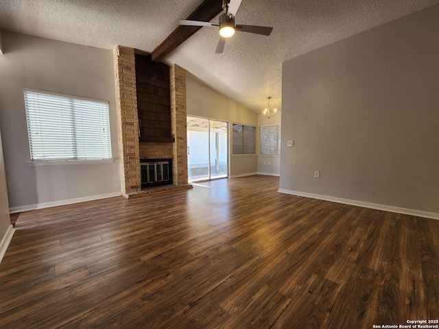 unfurnished living room featuring vaulted ceiling with beams, dark wood-type flooring, a textured ceiling, a brick fireplace, and ceiling fan with notable chandelier