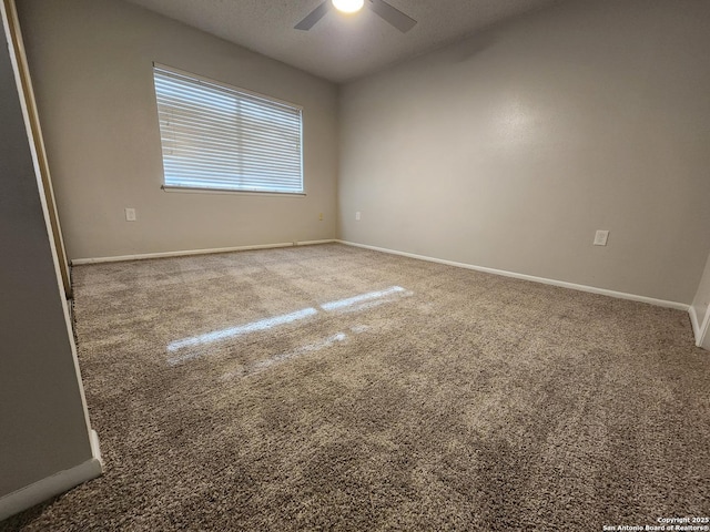 carpeted empty room featuring a textured ceiling, baseboards, and ceiling fan