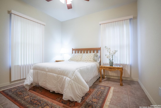 tiled bedroom with multiple windows, baseboards, and ceiling fan